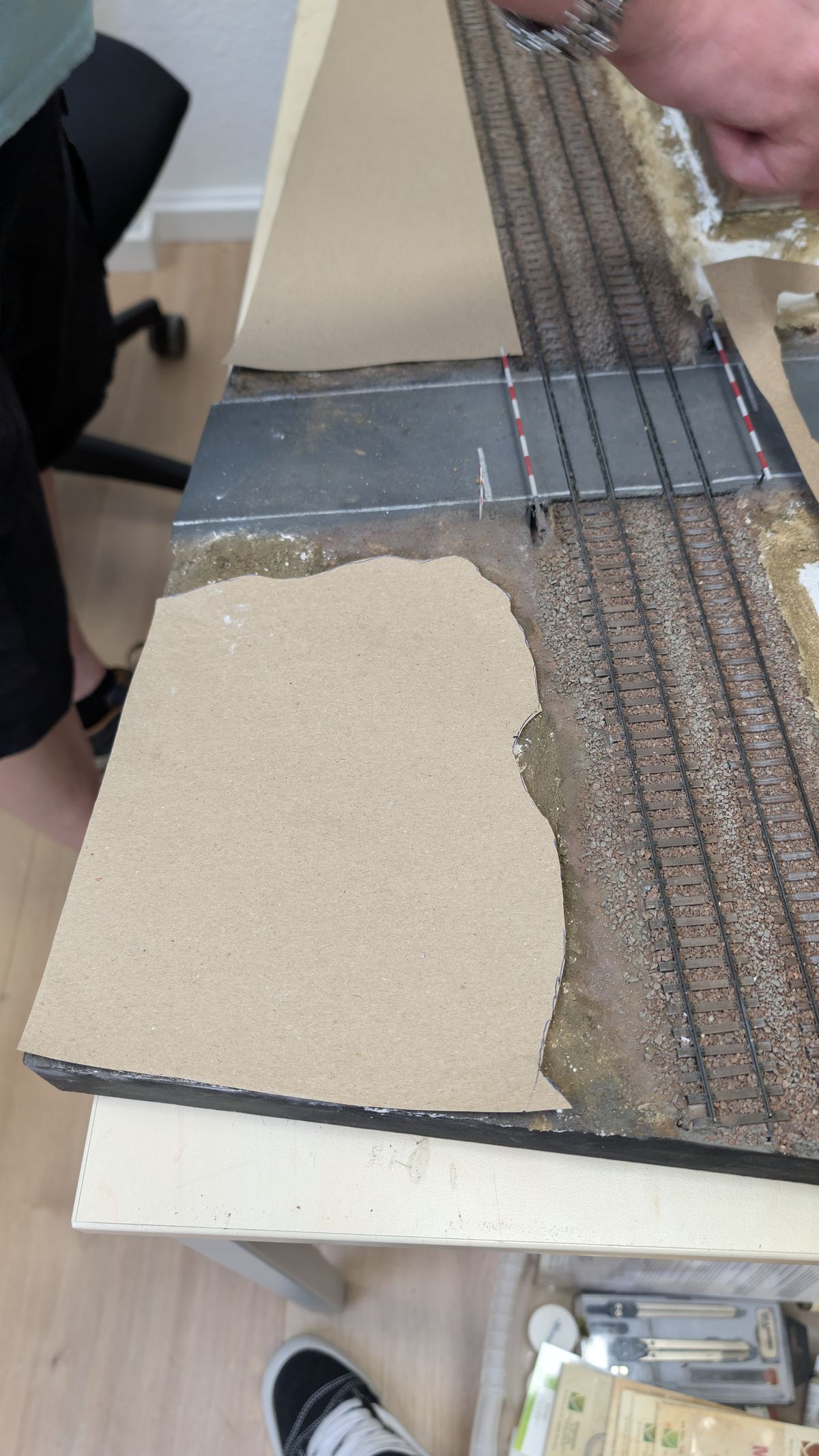 Zugeschnittene Papierschablone liegt passgenau auf der Gel&auml;ndefl&auml;che