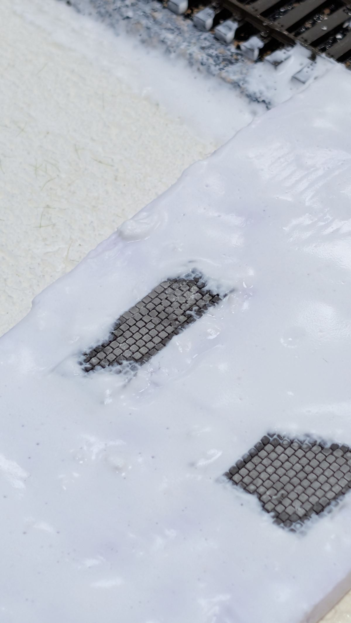 Wei&szlig;e Spachtelfl&auml;che mit b&uuml;ndig eingesetztem Pflasterfeld